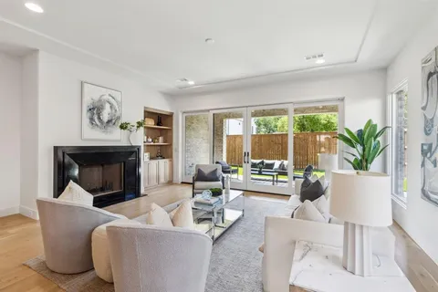 a living room with furniture a large window and a fireplace