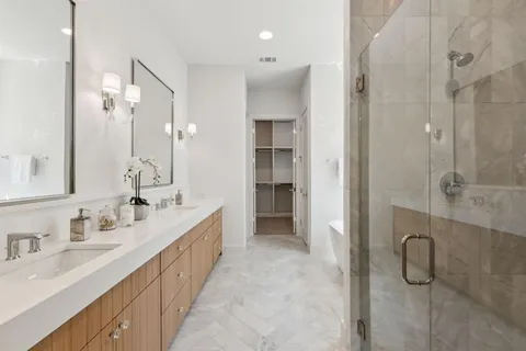 a bathroom with a double vanity sink mirror and shower