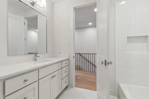 a bathroom with a sink and mirror with bathtub
