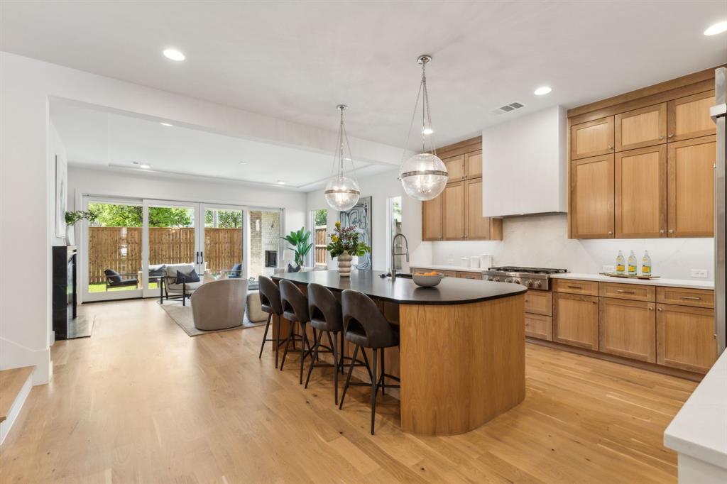 7611 Caillet Street Dallas, TX 75209 - Photo 5 of 37 a kitchen with stainless steel appliances granite countertop wooden floors stove top oven and cabinets