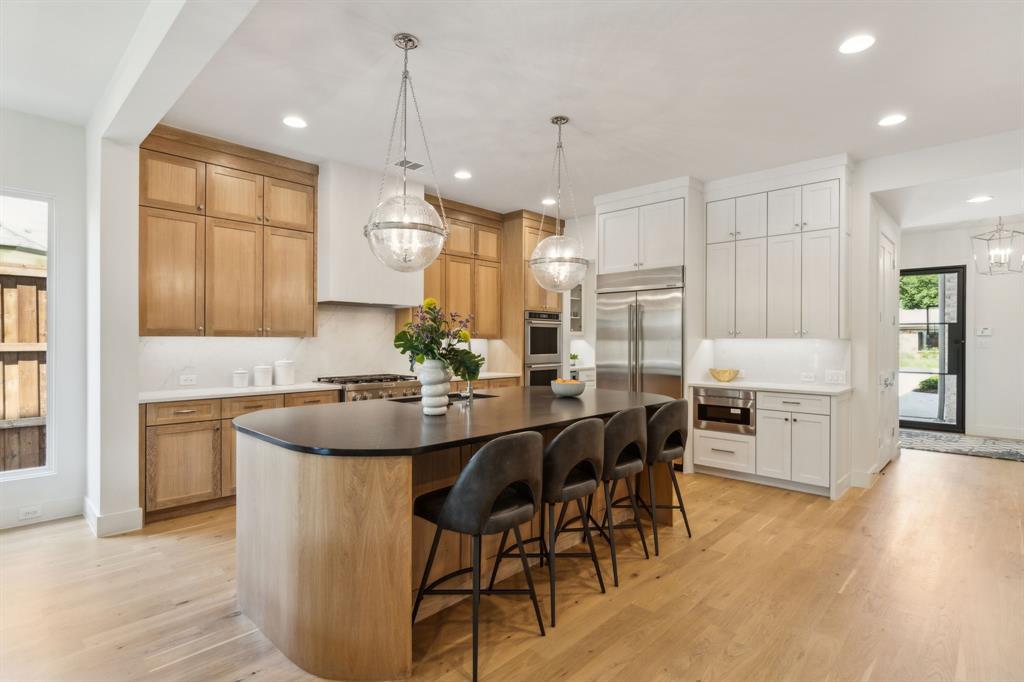 7611 Caillet Street Dallas, TX 75209 - Photo 7 of 37 a kitchen with stainless steel appliances kitchen island granite countertop a sink and refrigerator