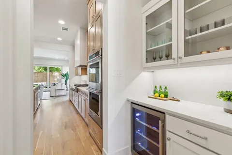 a view of a hallway with wooden floor and a living room