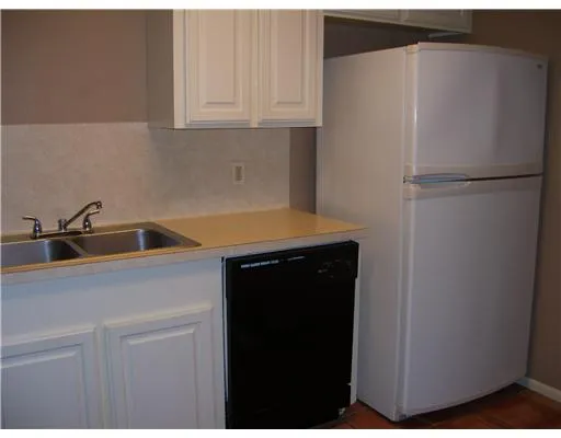 a kitchen with a refrigerator and cabinets