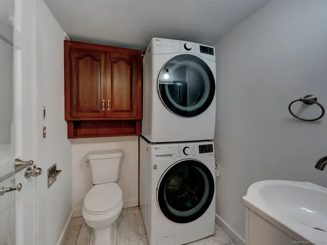 a view of a bathroom with a toilet sink washer and mirror