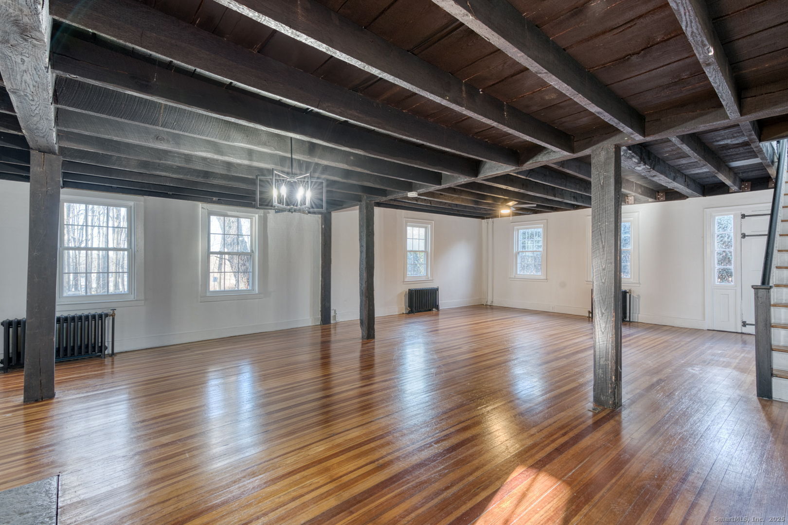 668 Middle Turnpike Mansfield, CT 06268 - Photo 27 of 40 a view of an empty room with wooden floor and a kitchen