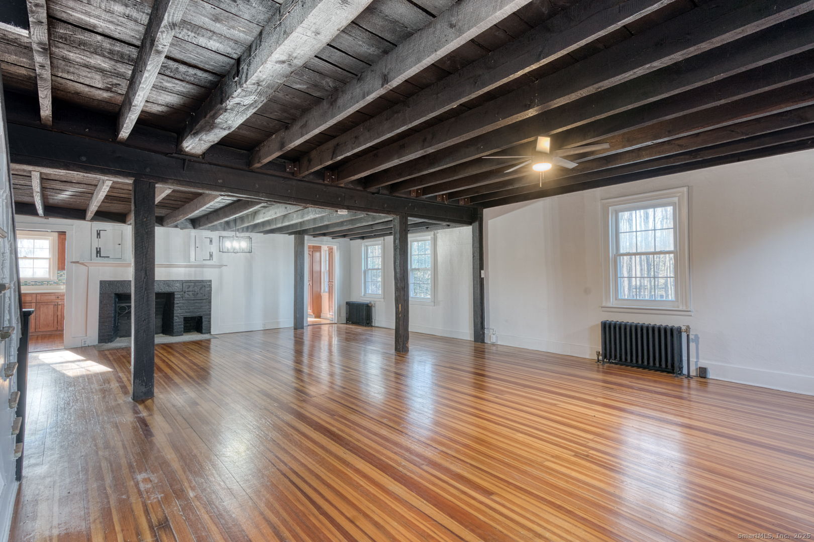 668 Middle Turnpike Mansfield, CT 06268 - Photo 30 of 40 a view of an empty room with wooden floor and a kitchen