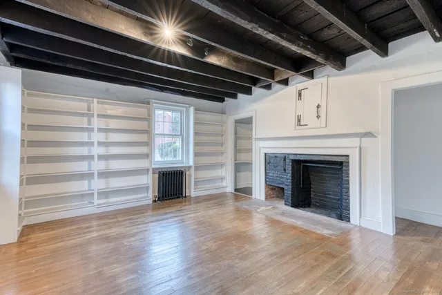 a view of an empty room with a fireplace and a window