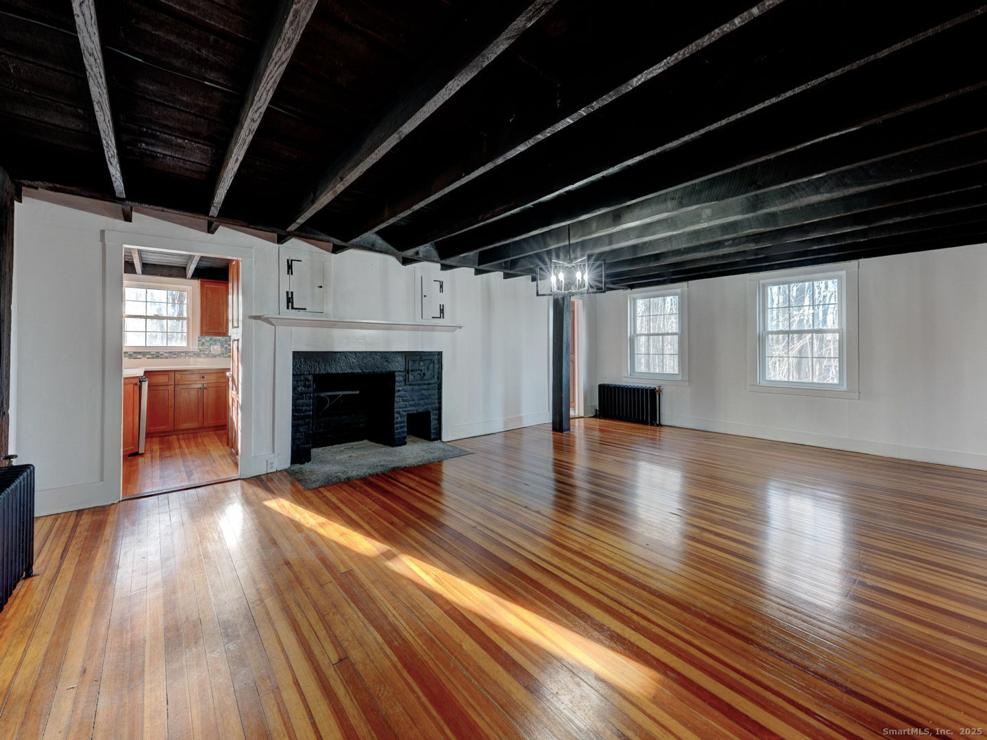 668 Middle Turnpike Mansfield, CT 06268 - Photo 4 of 40 a view of empty room with wooden floor and fireplace