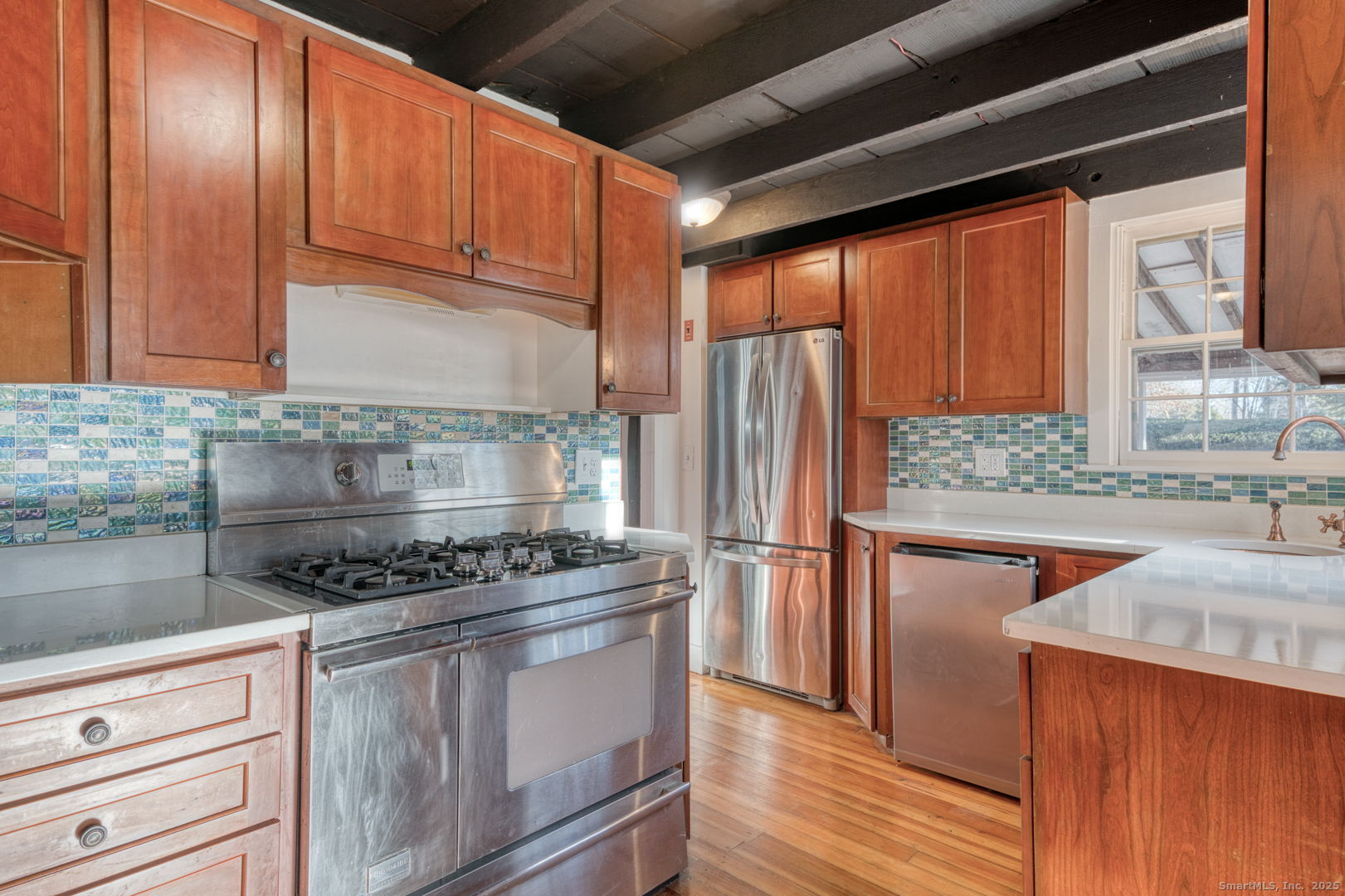 668 Middle Turnpike Mansfield, CT 06268 - Photo 8 of 40 a kitchen with stainless steel appliances granite countertop a refrigerator a sink and wooden cabinets