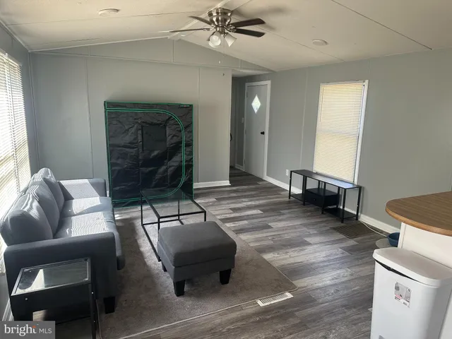 a living room with furniture and a wooden floor