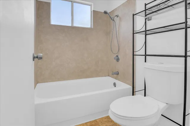 a white bath tub sitting next to a white toilet and sink