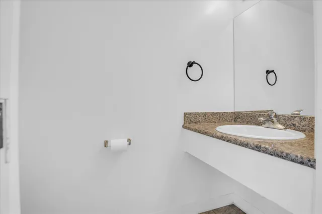a bathroom with a granite countertop sink and mirror