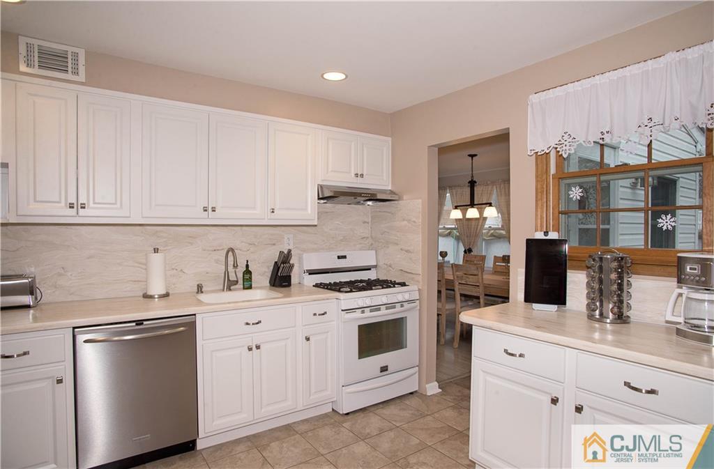 52 Idlewild Road Edison, NJ 08817 - Photo 9 of 21 a kitchen with granite countertop white cabinets and white appliances