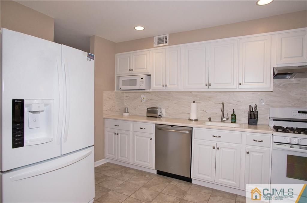 52 Idlewild Road Edison, NJ 08817 - Photo 10 of 21 a kitchen with white cabinets and white appliances