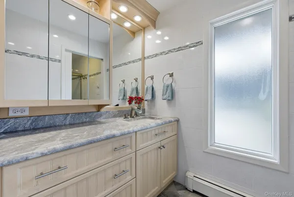a bathroom with a granite countertop sink a mirror and a shower