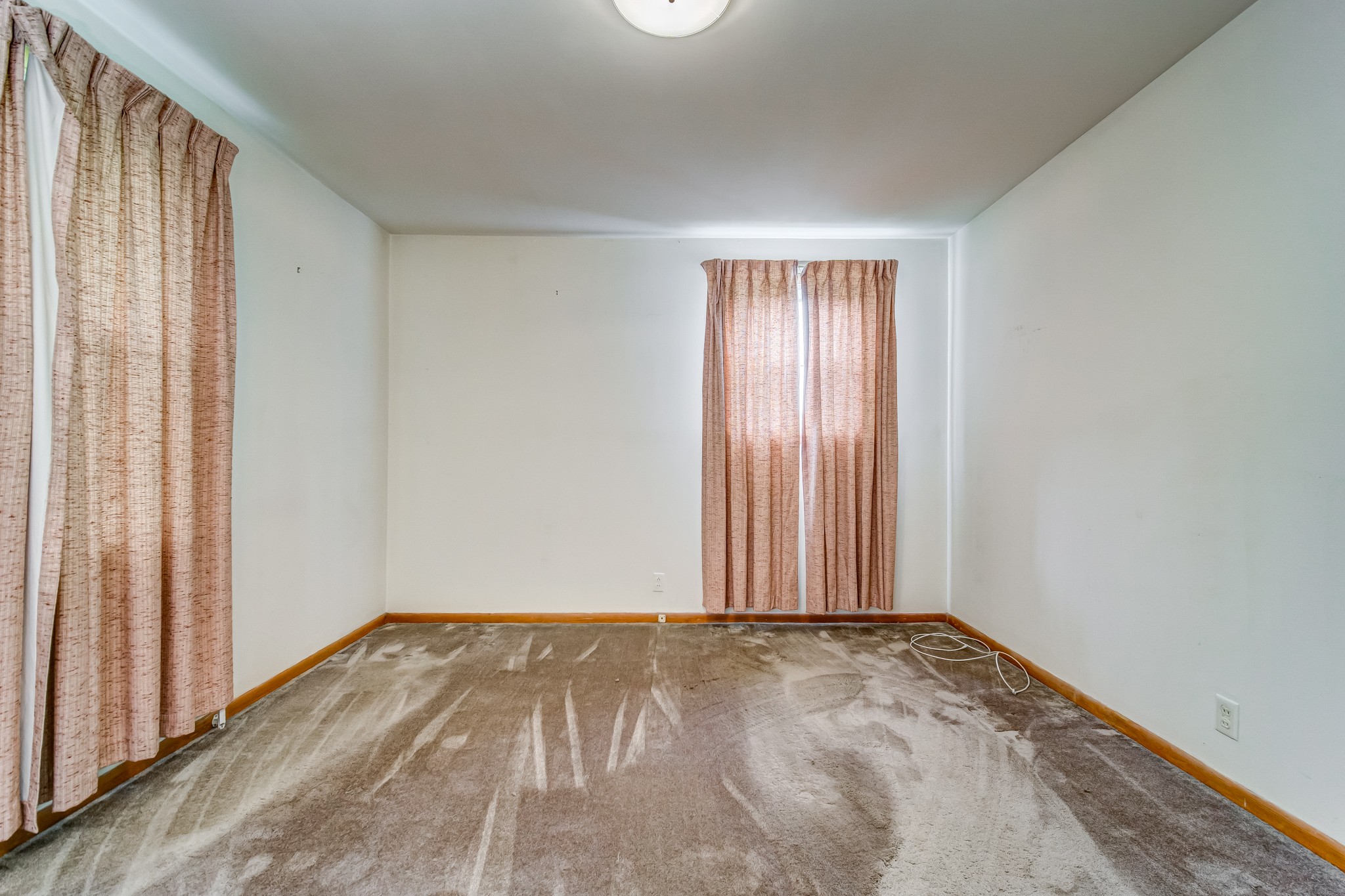 1377 Deal Road Burns, TN 37029 - Photo 32 of 47 an empty room with wooden floor and windows with curtains