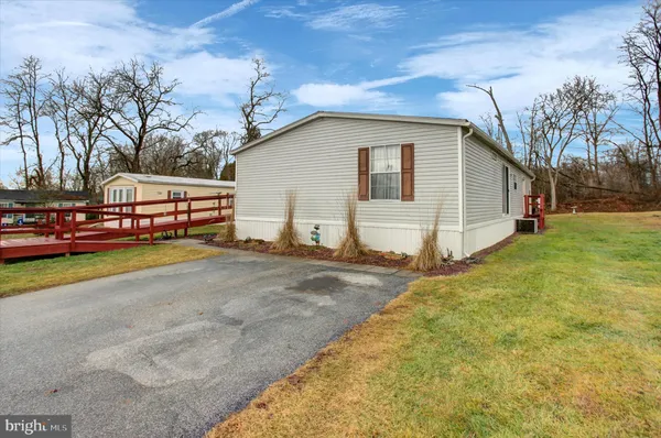 a view of a house with a backyard and trees