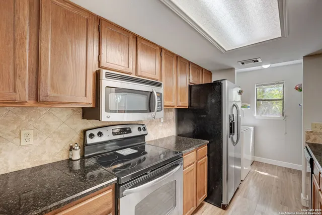 a kitchen with stainless steel appliances granite countertop a refrigerator stove and sink
