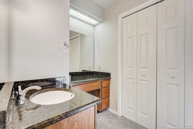 a bathroom with a granite countertop sink and a mirror
