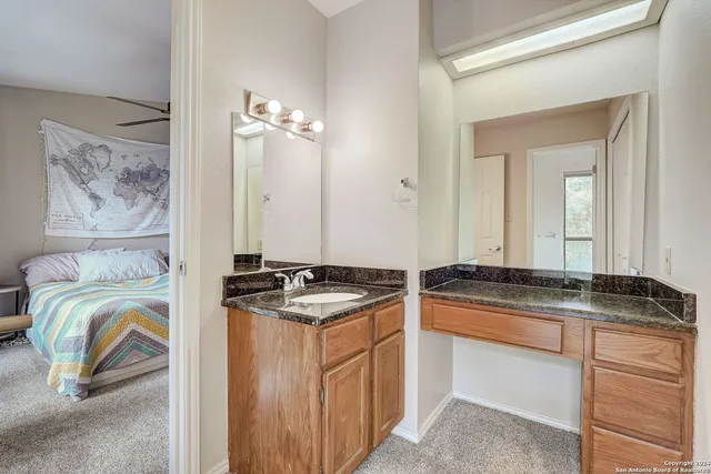 a bathroom with a granite countertop sink a mirror and shower