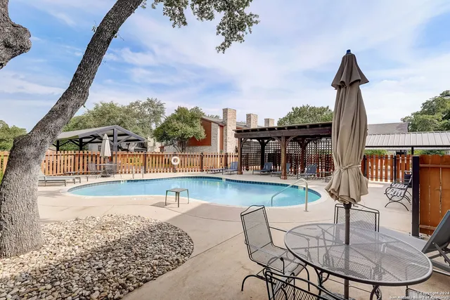 a view of a swimming pool with a patio and a garden