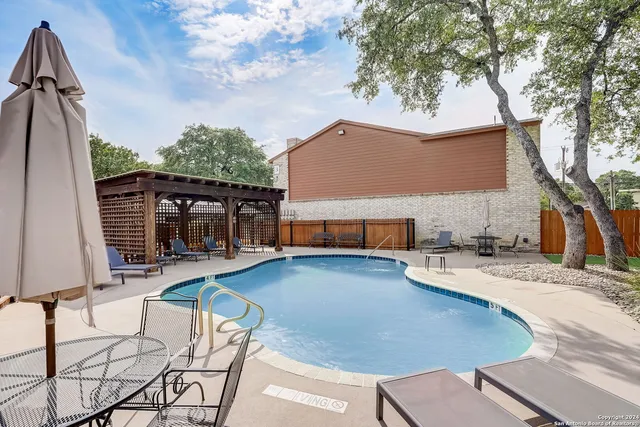 a view of house with backyard and furniture