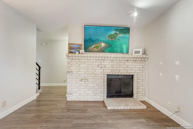 a view of empty room with wooden floor and fireplace