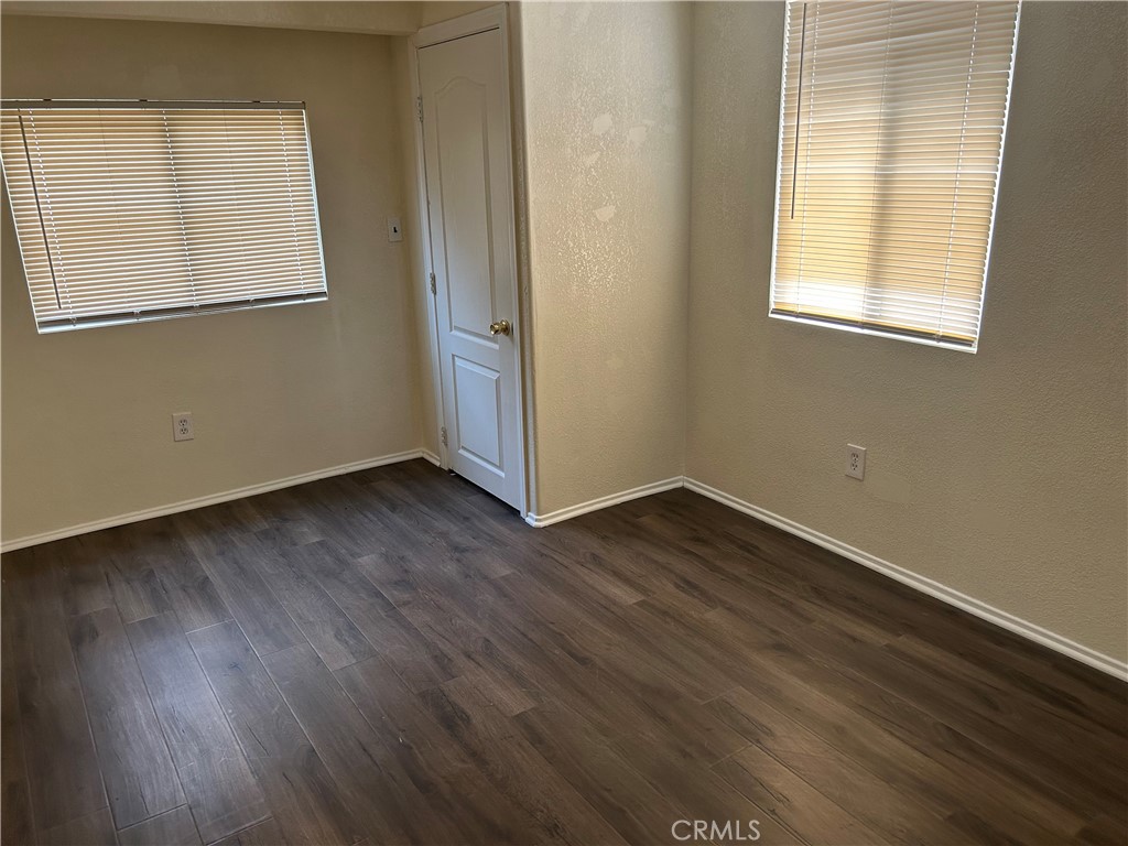632 North Birch Avenue, Unit B Rialto, CA 92376 - Photo 5 of 8 an empty room with wooden floor and windows