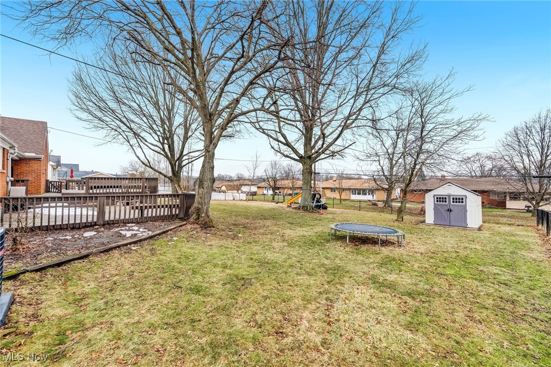 1051 Rockside Road Independence, OH 44131 - Photo 29 of 30 View of yard featuring a trampoline, a storage unit, fence, and an outbuilding