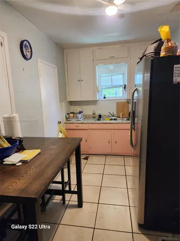 a kitchen with stainless steel appliances granite countertop a sink a stove a refrigerator a dining table and chairs with wooden floor