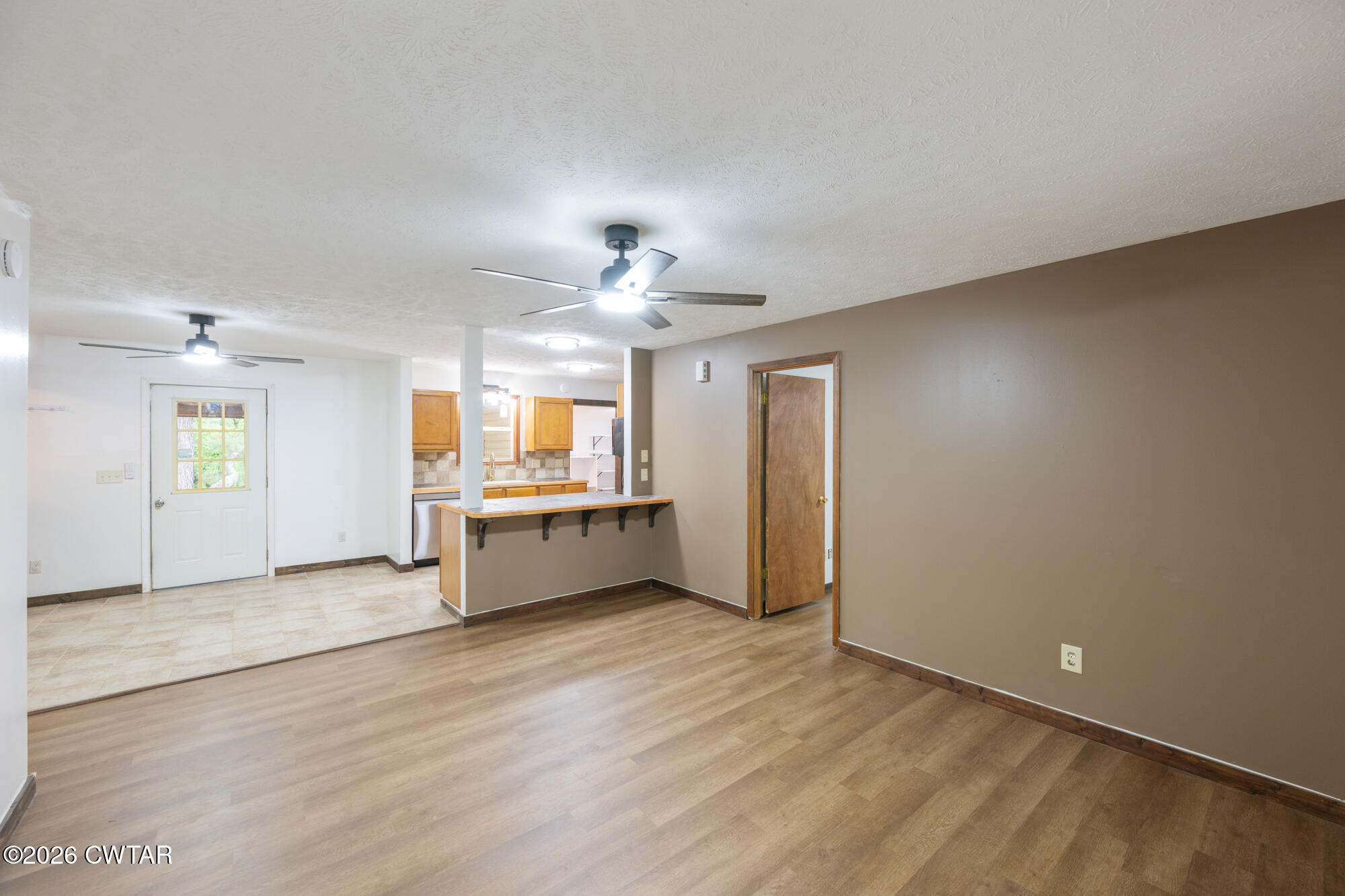 2827 Chapel Hill Road McKenzie, TN 38201 - Photo 12 of 40 an empty room with wooden floor kitchen view and a window