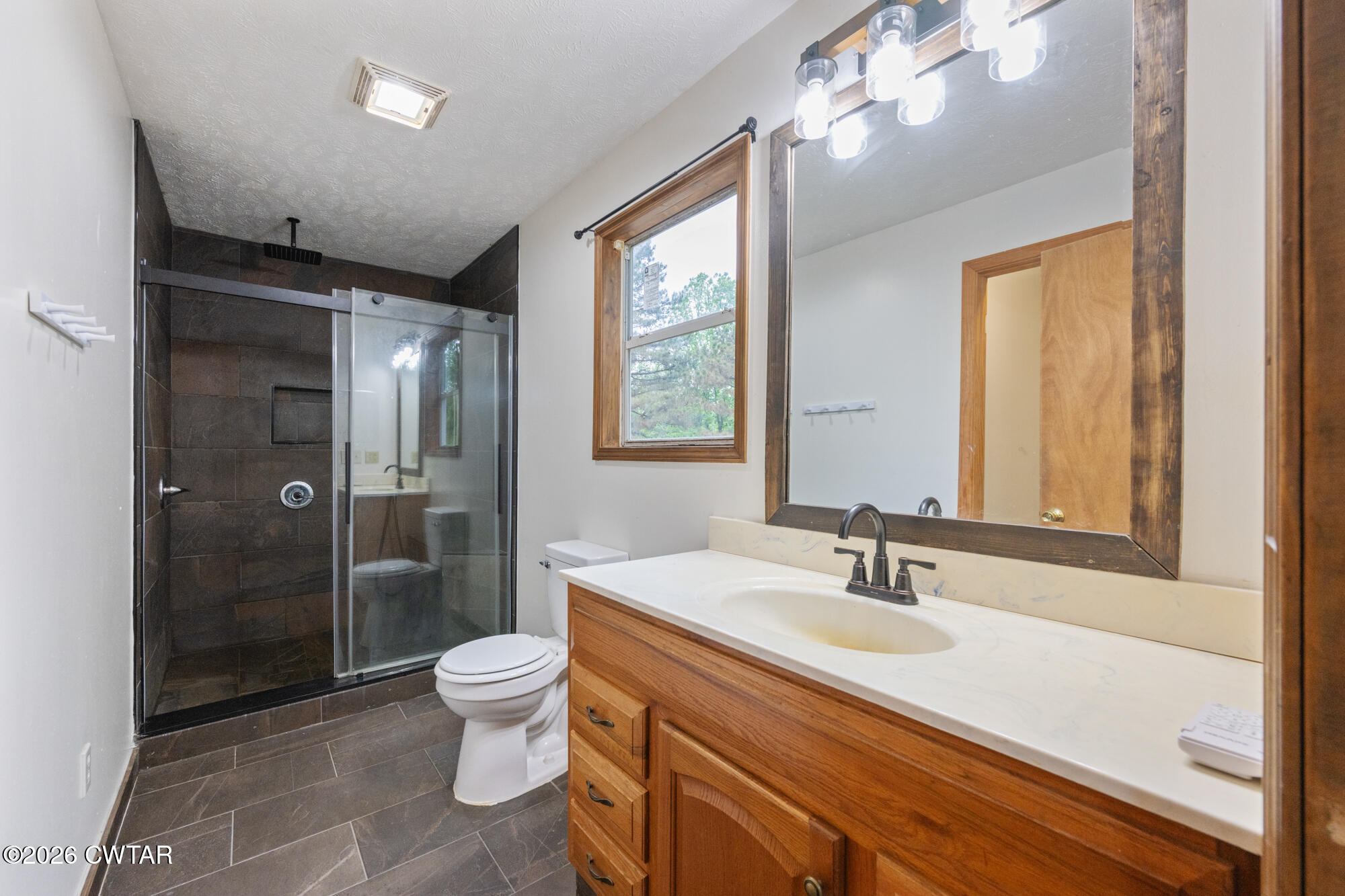 2827 Chapel Hill Road McKenzie, TN 38201 - Photo 19 of 40 a bathroom with a sink a toilet a large mirror and shower