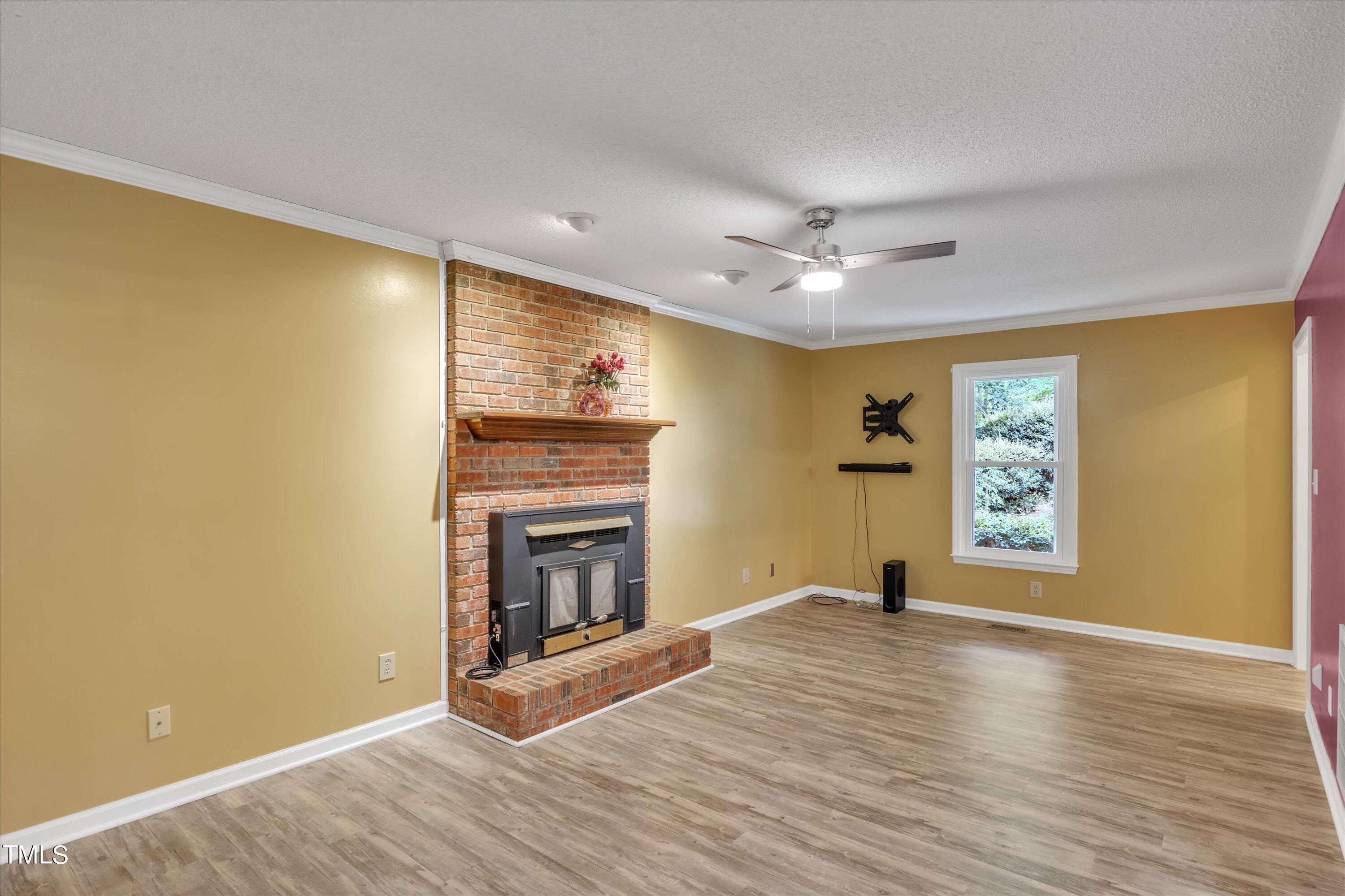 9208 Tree Meadow Lane Raleigh, NC 27603 - Photo 16 of 61 a view of an empty room with a fireplace and a window