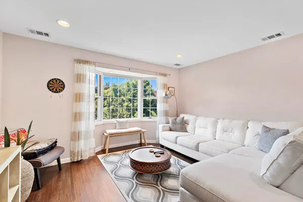 a living room with stainless steel appliances kitchen island granite countertop furniture and a wooden floor