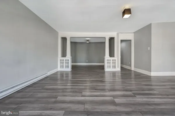 a view of empty room with wooden floor