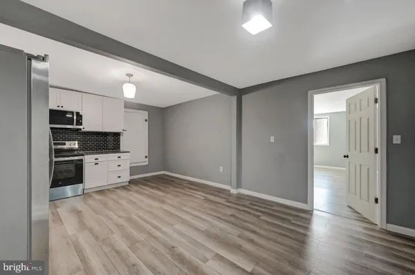 a view of kitchen with wooden floor electronic appliances and window