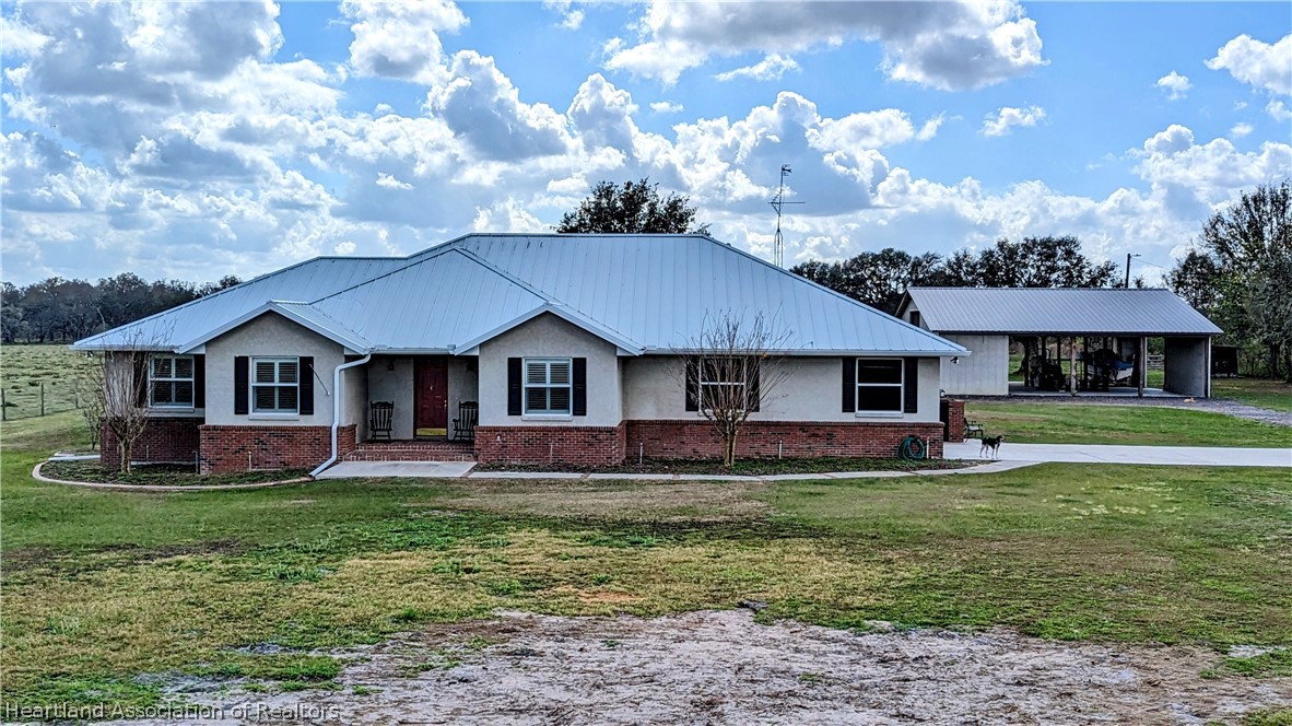 2120 Jack Smith Road Zolfo Springs, FL 33890 - Photo 1 of 36 a front view of a house with a garden and trees