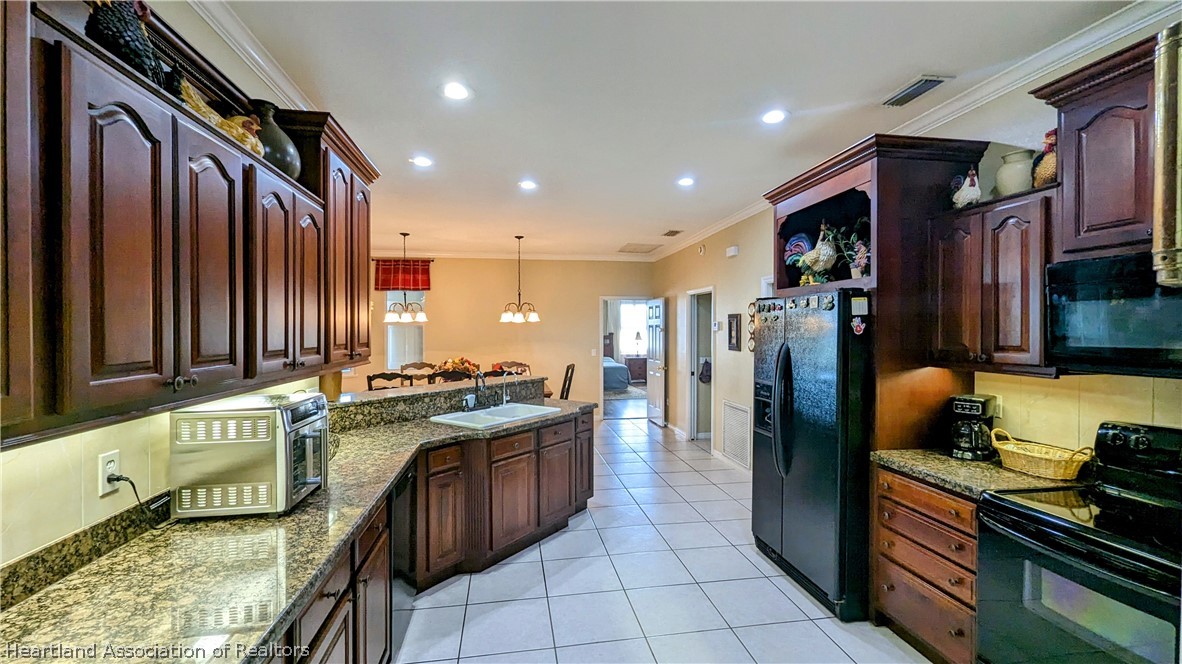 2120 Jack Smith Road Zolfo Springs, FL 33890 - Photo 15 of 36 a kitchen with stainless steel appliances granite countertop a stove a sink and a refrigerator