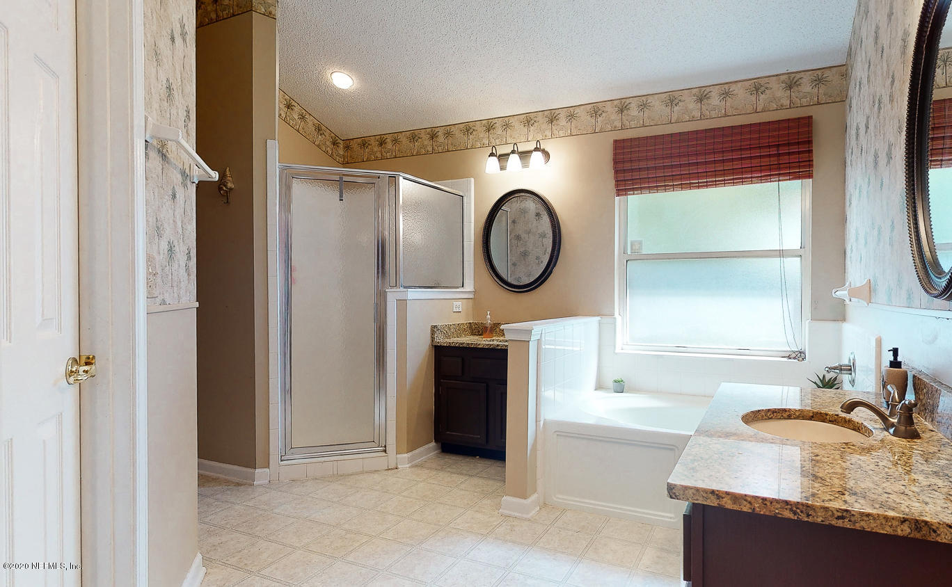 8232 Leafcrest Drive Jacksonville, FL 32244 - Photo 16 of 33 a spacious bathroom with a granite countertop sink mirror and bathtub