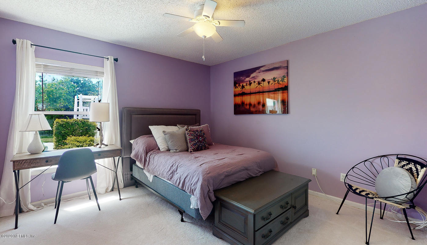 8232 Leafcrest Drive Jacksonville, FL 32244 - Photo 17 of 33 a bedroom with a bed and a chandelier