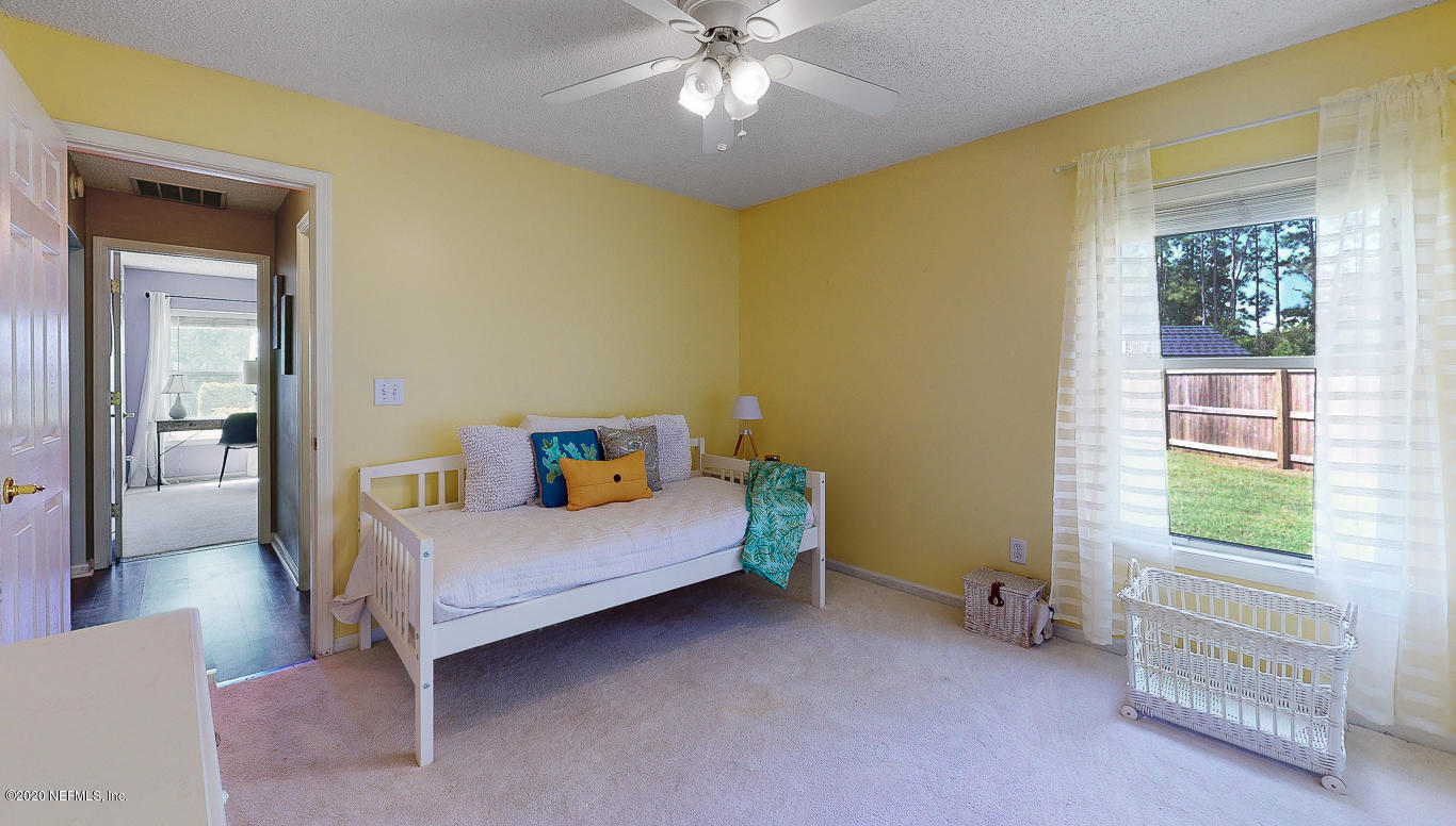 8232 Leafcrest Drive Jacksonville, FL 32244 - Photo 19 of 33 a bedroom with a bed and a chandelier