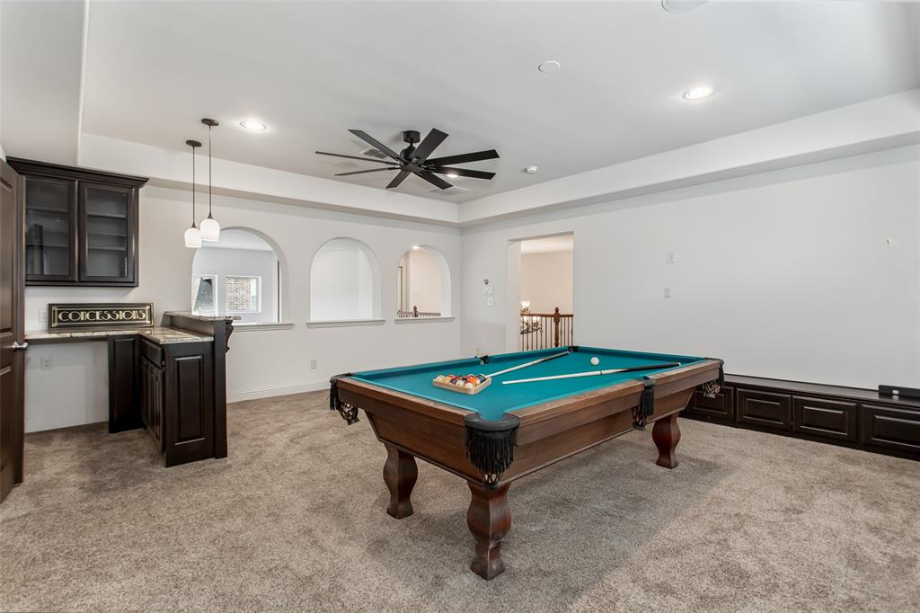 846 Deerfield Road Allen, TX 75013 - Photo 30 of 40 Spacious recreation room featuring a built-in wet bar with dark wood cabinetry, granite-style countertop, and pendant lighting