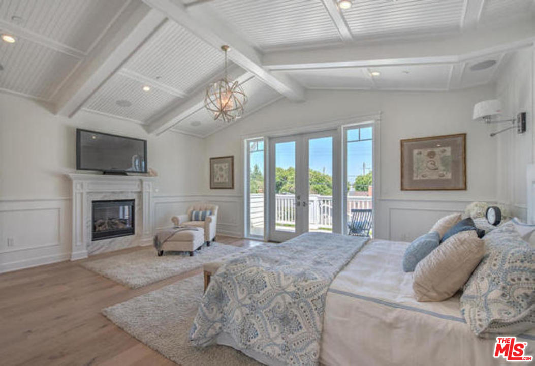 17841 Palora Street Encino, CA 91316 - Photo 16 of 33 a bedroom with a large bed and a fireplace