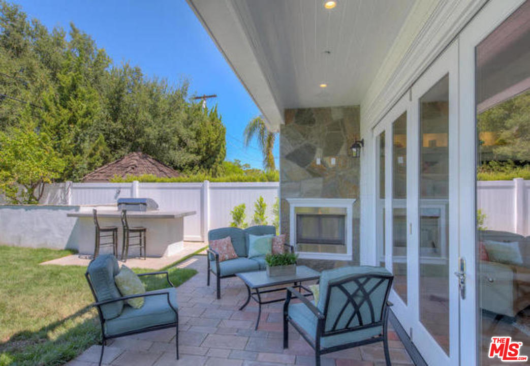 17841 Palora Street Encino, CA 91316 - Photo 27 of 33 a view of a patio with couches table and chairs and potted plants