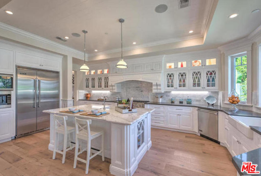 17841 Palora Street Encino, CA 91316 - Photo 8 of 33 a kitchen with stainless steel appliances granite countertop a stove a refrigerator a sink dishwasher with a dining table and chairs
