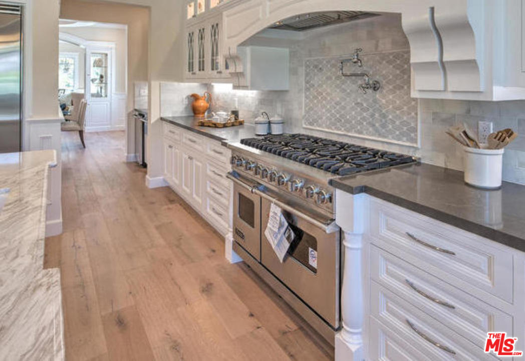 17841 Palora Street Encino, CA 91316 - Photo 9 of 33 a kitchen with granite countertop a stove and a wooden floors