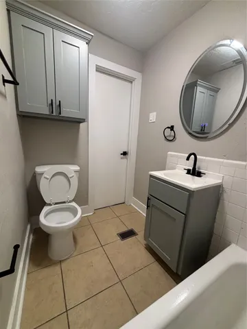a bathroom with a toilet a sink and mirror