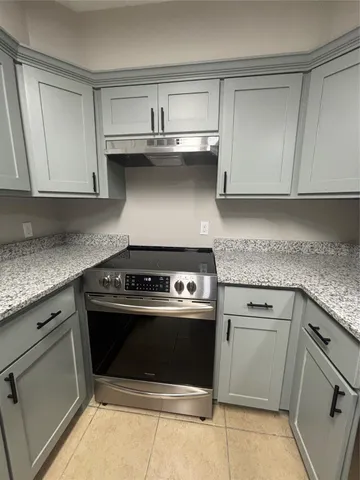 a kitchen with granite countertop a stove and a sink