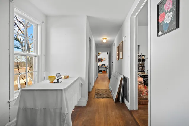 a hallway with furniture and wooden floor
