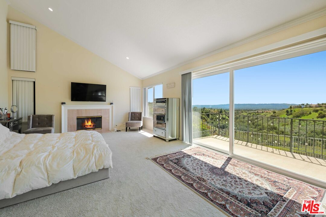 19800 Winged Foot Way Porter Ranch, CA 91326 - Photo 19 of 48 a spacious bedroom with a large bed and a fireplace